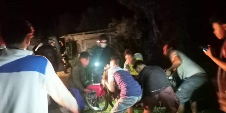 FOTO : IST/MATAKALTENG - Warga setempat saat membantu menaikan motor korban lakalantas, Selasa 25 Januari 2022 malam.