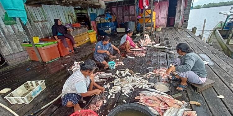 FOTO: ALDI SETIAWAN/MATA KALTENG: Sejumlah masyarakat pada saat membersihkan ikan hasil tangkapan nelayan di TPI.