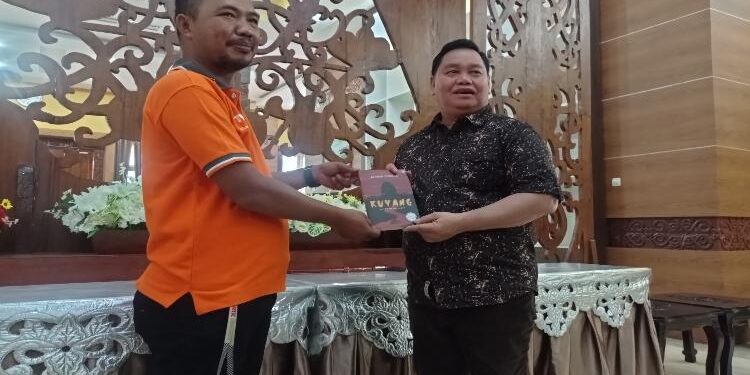 DEV IANA/MATAKALTENG - Bupati Kotim Halikinnor saat menerima buku karya Achmad Benbela, Jumat 11 Februari 2022.