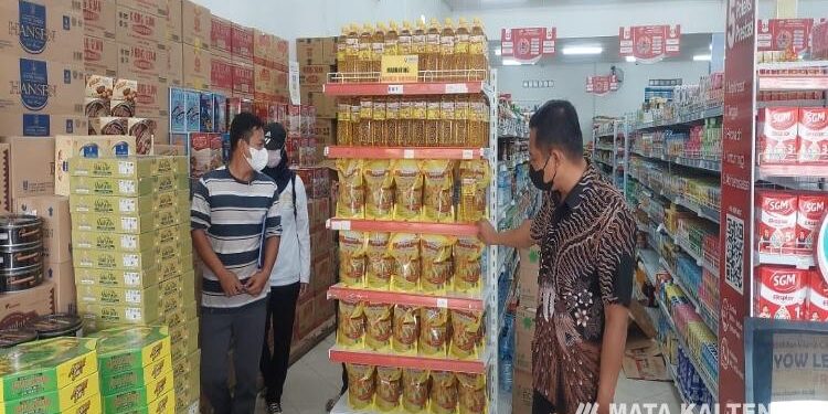 FOTO : IST/MATAKALTENG - Kapolres Lamandau (kanan) saat memantau ketersediaan minyak goreng di sejumlah toko di Nanga Bulik.