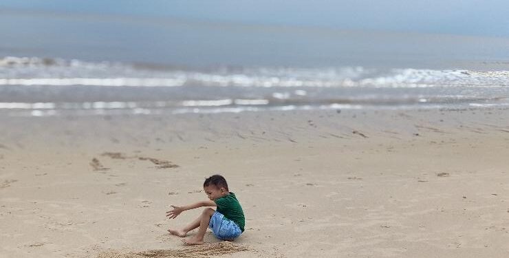 FOTO : RAFI/MATAKALTENG - Salah seorang anak asyik bermain pasir di Pantai Ujung Pandaran, Kecamatan Teluk Sampit, Kabupaten Kotim.