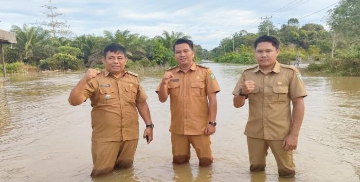 FOTO : IST/MATAKALTENG - Camat Tualan Hulu, Admadi Satra (kiri), bersama pegawai kecamatan ketika meninjau banjir di Desa Tanjung Jorong.