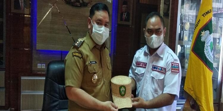 FOTO : IST/MATAKALTENG - Ketua UMKM Harati, Rahmat Kotim saat menyerahkan produk olahannya kepada Bupati Kotim.