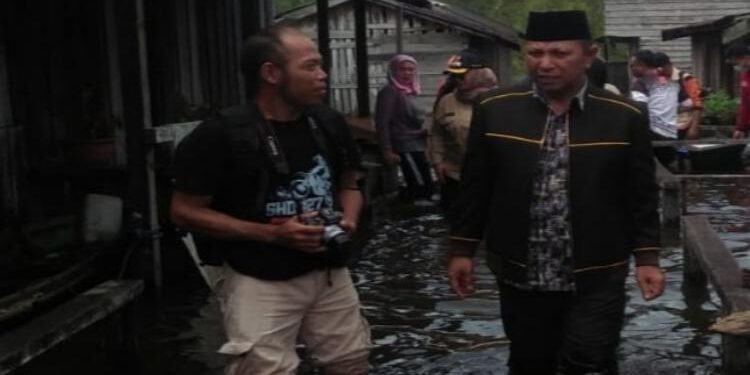 FOTO : Staf DPRD for MATAKALTENG - Rudianur saat mengunjungi wilayah banjir di Kecamatan Mentaya Hilir Utara. 