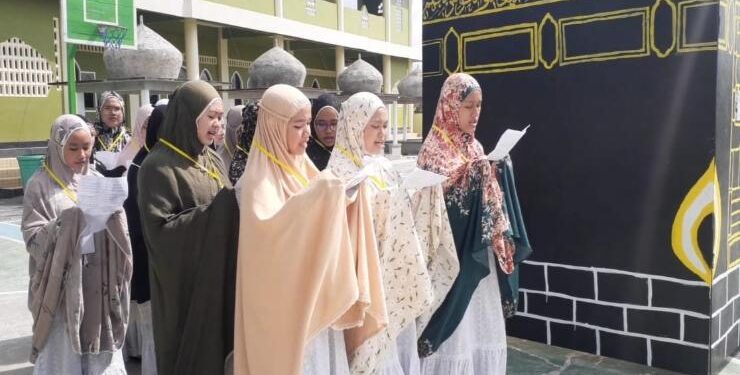 FOTO : IST/MATAKALTENG - Puluhan siswi SMA IT Arafah Sampit melaksanakan praktek umrah di lingkungan sekolah, Sabtu 23 Juli 2022.