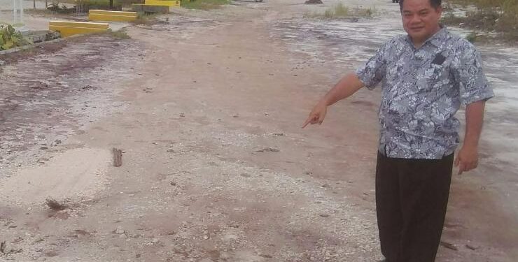FOTO : UNTUNG JAYA BANGAS/MATA KALTENG - Anggota DPRD Kabupaten Gumas Untung Jaya Bangas menunjukkan kondisi jalan rusak menuju kantor OPD, Selasa, 26 Juli 2022.
