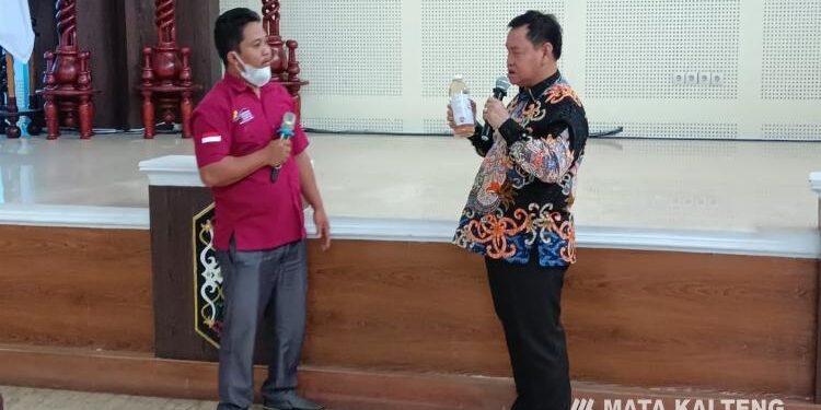 FOTO : DOKUMENTASI MATAKALTENG - Koordinator PKH Teluk Sampit Zulfikar, mengenalkan minyak goreng dari kelapa kepada Bupati Kotim, Halikinnor.