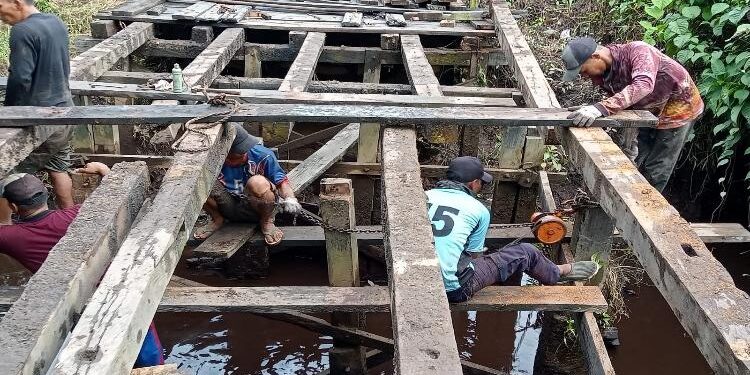 FOTO : IST/MATAKALTENG - Warga melakukan perbaikan jembatan di Desa Basirih Hulu, Jumat 26 Agustus 2022.