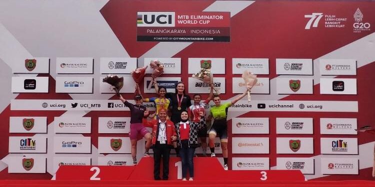 FOTO: OLIVIA/MATAKALTENG - Ayu dan pemenang kategori woman elite berfoto di podium bersama OC UCI MTB Eliminator World Cup 2022, Agustiar Sabran. 