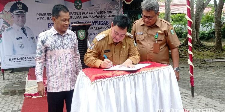 FOTO : DEVIANA/MATAKALTENG - Bupati Kotim Halikinnor saat menandatangani SK purnatugas Lurah Baamang Barat, disaksikan oleh Jainurul Arifin  dan Parliansyah, Senin 1 Agustus 2022.