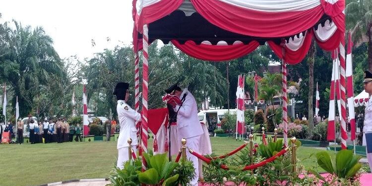 FOTO : DEVIANA/MATAKALTENG - Bupati Kotim Halikinnor saat mencium bendera merah putih sebelum diberikan kepada petugas Paskibraka, Rabu 17 Agustus 2022.