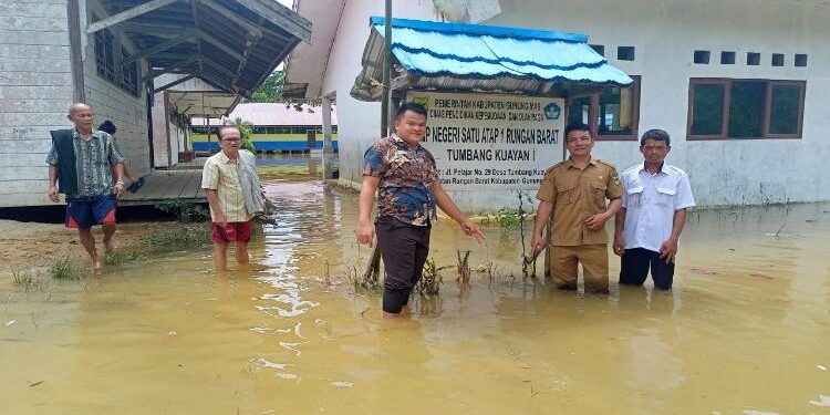 FOTO : PEBRIANTO/MATA KALTENG - Anggota DPRD Gumas Pebrianto (baju batik) didampingi Kepala Desa dan Sekretaris Desa Tumbang Kuayan, meninjau kondisi sekolah yang terkena banjir di desa setempat. 