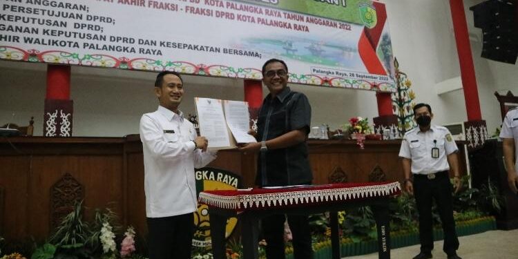 FOTO: AULIA/MATAKALTENG - Walikota Palangka Raya, Fairid Naparin (Kiri) dan Ketua DPRD Kota Palangka Raya (kanan) menunjukan nota kesepakatan perubahan APBD Kota Palangka Raya Tahun 2022.