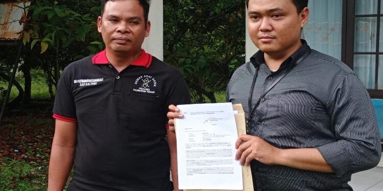 FOTO: RIZAL/MATAKALTENG - Suami sah RA, Risko (kanan) pada saat menunjukkan surat laporan ke Kedamangan Pahandut.