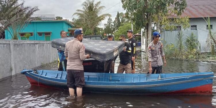 FOTO : AKH/MATAKALTENG - Anggota Polri saat melakukan evakuasi barang-barang milik warga yang terkena banjir.