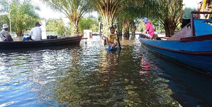 FOTO : DEVIANA/MATAKALTENG - Aktivitas warga Desa Hanjalipan menggunakan perahu lantaran jalan terendam air, Sabtu 8 Oktober 2022.