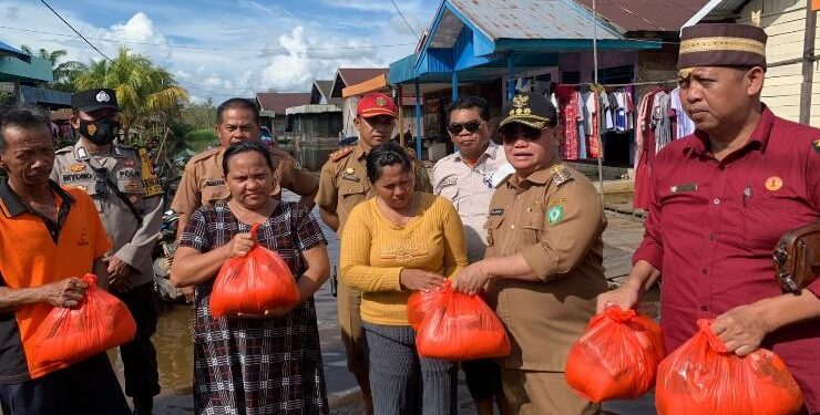 FOTO : DEVIANA/MATAKALTENG - Bupati Kotim Halikinnor bersama Kepala OPD dan camat saat menyerahkan bantuan kepada warga Kecamatan Telawang, Senin 24 Oktober 2022.