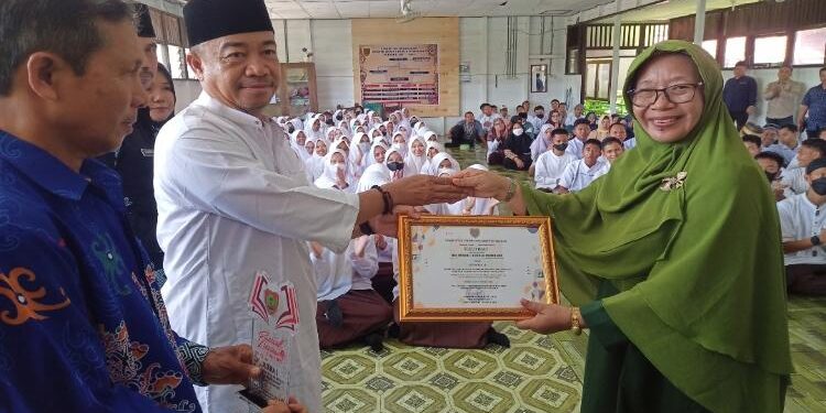 FOTO: ALDI/MATA KALTENG - Bupati Seruyan, Yulhaidir saat menyerahkan piagam penghargaan dari Dispursip Kalteng kepada Kepala SMA Negeri 1 Kuala Pembuang di sekolah setempat baru-baru ini.