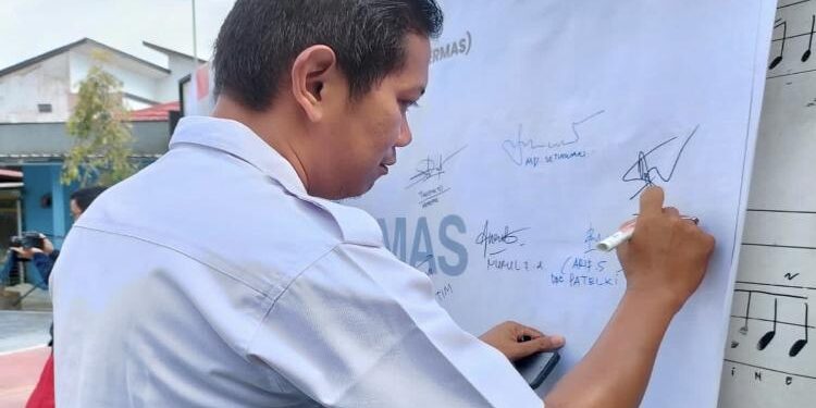 FOTO : DIAN/MATA KALTENG - Asisten I, Diana Setiawan saat menandatangani komitmen bersama aksi bergizi.