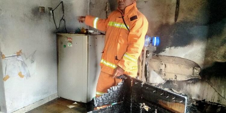 FOTO: AGUS/MATA KALTENG - Salah satu petugas menunjukan bangunan yang terbakar di lokasi kejadian, Rabu 2 November 2022 siang.