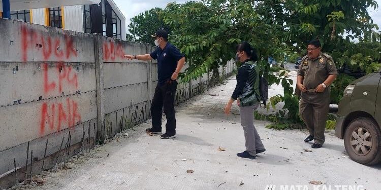 FOTO: RIZAL/MATAKALTENG - Jajaran Satpol-PP Kota Palangka Raya, pada saat menghapus aksi vandalisme di tembok SPBU Jalan Ir. Soekarno Kota Palangka Raya.