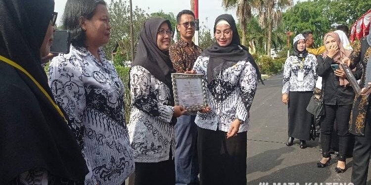 FOTO : DEVIANA/MATAKALTENG - Kepala SDS Anwar Karim VI Irma Handayani Surbakti saat menerima penghargaan Adiwiyata tingkat nasional yang diserahkan oleh Wakil Bupati Kotim Irawati, Sabtu, 3 Desember 2022.