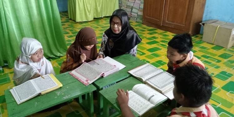FOTO : IST/MATAKALTENG - Guru SDN 6 MB Hulu Sampit saat melakukan pembimbingan baca Al-Quran. 