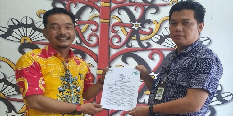 FOTO : SID/MATA KALTENG - Pimpinan Bank Kalteng Cabang Kuala Kurun Jeksenly dan Direktur PDAM Tirta Bahalap Gunung Mas Hendra Toendan, menunjukkan surat perjanjian kerjasama terkait pembayaran tagihan PDAM.