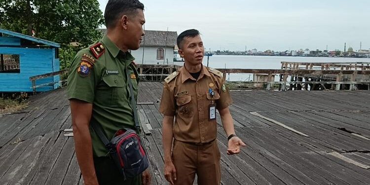 FOTO : IST/MATAKALTENG - Lurah Mentaya Seberang Reza Aji Maulana Abdi bersama Komandan BKSDA Pos Jaga Sampit Muriansyah saat akan memasang papan imbauan.