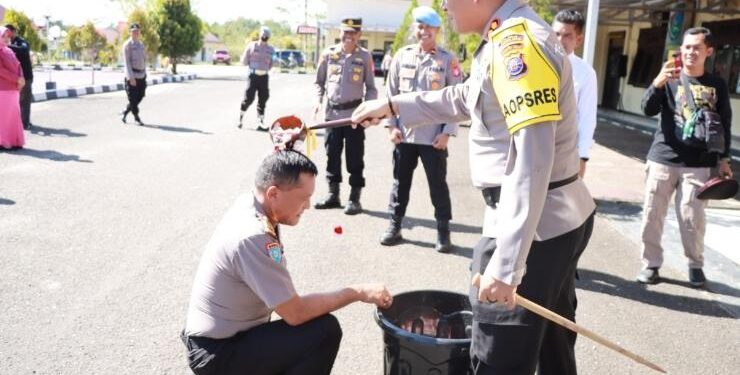 FOTO : HUMAS POLRES GUMAS/MATA KALTENG - Kapolres Gumas AKBP Irwansah melakukan penyiraman bunga kepada personel yang naik pangkat setingkat lebih tinggi, di Lapangan Tantya Sudhirajati, Sabtu, 31 Desember 2022.