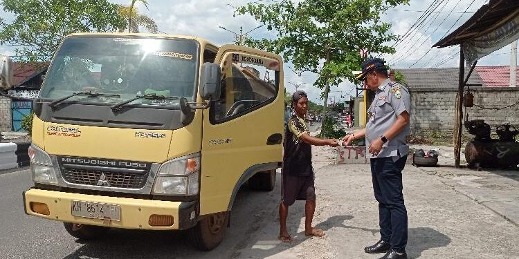 FOTO : DEVIANA/MATAKALTENG - Kadishub Kotim Johny Tangkere saat melakukan pengecekan surat kendaraan driver truk CPO di Jalan Tjilik Riwut terhadap truk CPO yang melintas, Kamis 12 Januari 2023.
