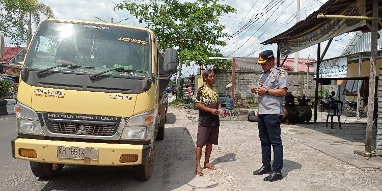 FOTO : DEVIANA/MATAKALTENG - Kadishub Kotim Johny Tangkere, saat memeriksa kelengkapan surat kendaraan sopir yang terazia.