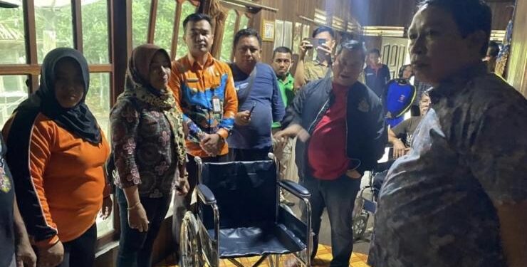FOTO : HUMAS/MATA KALTENG - Penyerahan bantuan kursi roda oleh Bupati Kotim kepada salah seorang warga yang mengalami kelumpuhan.
