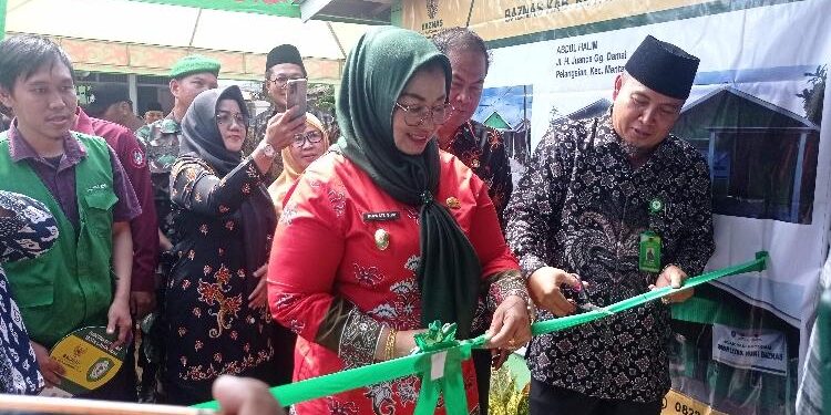 FOTO : DEVIANA/MATAKALTENG - Wakil Bupati Kotim Irawati didampingi Ketua BAZNAS Kotim Sarifudin saat memotong pita peresmian rumah yang direnovasi, Kamis 19 Januari 2023