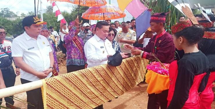 FOTO : RAFI/MATAKALTENG - Bupati Kotim Halikinnor didampingi Ketua DPRD Rinie Anderson dan Sekda Kotim Fajrurrahman saat upacara adat penyambutan tamu di Desa Tumbang Penyahuan, Rabu 25 Januari 2023.
