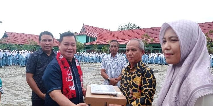FOTO : DEVIANA/MATAKALTENG - Bupati Kotim Halikinnor saat menyerahkan bantuan laptop kepada Kepala SMAN 3 Sampit Livenur Hasby, Jumat 27 Januari 2023.
