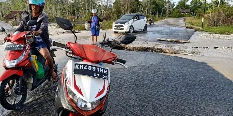 FOTO : WARGA/MATA KALTENG - Ruas jalan kabupaten yang rusak akibat tergerus luapan air sungai, yang berada di perbatasan Kelurahan Tampang Tumbang Anjir dengan Desa Tanjung Riu, pekan lalu.