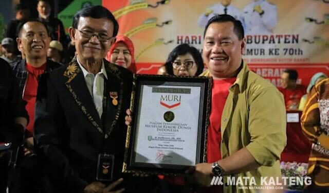 FOTO : Humas/MATA KALTENG - Bupati Kotim saat terima piagam penghargaan rekor muri tiang lampu jalan dengan hiasan etnik terbanyak.