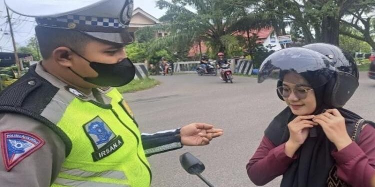 FOTO : IST/MATA KALTENG - Anggota Satlantas Polres Kotim saat memberikan imbauan terhadap pengendara motor agar mengklik keamanan pada helm.