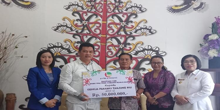 FOTO : DISKOMINFO SANTIK/MATA KALTENG - Wakil Bupati Gumas Efrensia LP Umbing (ujung kanan) ketika menyaksikan penyerahan CSR oleh Pimpinan Bank Kalteng Cabang Kuala Kurun Jeksenly kepada Ketua Pembangunan Gereja Parawei Adelman, Rabu, 1 Februari 2023.