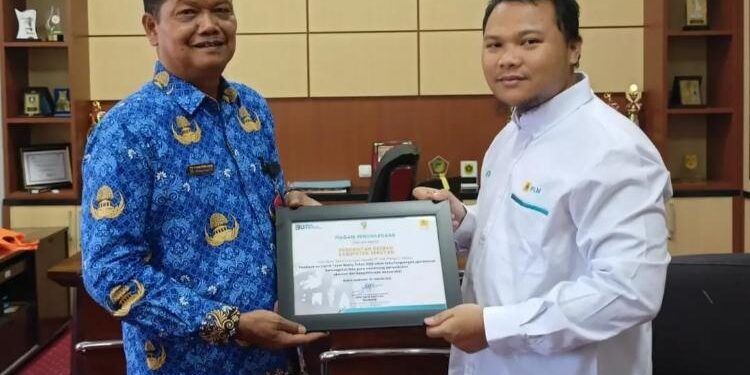FOTO: PROKOM SERUYAN/MATA KALTENG - Sekda Seruyan, Djainu'ddin Noor (kiri) saat menerima piagam penghargaan dari PLN setempat karena tepat waktu membayar listrik di ruang kerjanya, Senin 20 Februari 2023.