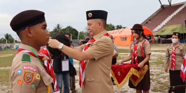 FOTO : DISKOMINFO SANTIK/MATA KALTENG - Bupati Gumas Jaya Samaya Monong didampingi Ketua Kwartir Cabang Gerakan Pramuka Mimie Mariatie Jaya S Monong, saat menyematkan tanda peserta, sebagai tanda dimulainya lomba tingkat III dan raimuna cabang tahun 2023, di Stadion Mini Kuala Kurun, Jumat, 24 Februari 2023.