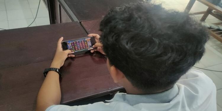 Foto Ilustrasi seorang pria sedang bermain judi slot.