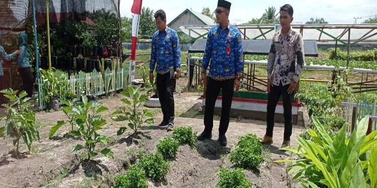 FOTO : DEVIANA/MATAKALTENG - Kepala DPMD Raihansyah dan tim penilaian saat memantau kebun toga Desa Bagendang Tengah, Jumat 17 Maret 2023.