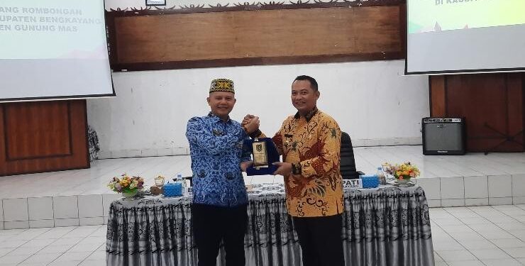 FOTO : SID/MATA KALTENG - Bupati Gumas Jaya S Monong menyerahkan plakat pemkab kepada Bupati Bengkayang Sebastianus Darwis, di Aula Kantor Bappedalitbang setempat, Jumat, 17 Maret 2023.