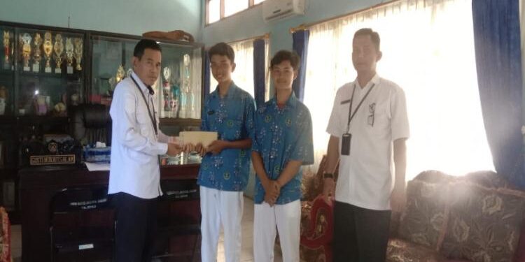 FOTO : Pemerintah Kecamatan Kobes/MATA KALTENG - Camat Kota Besi Gusti Mufaki saat memberikan penghargaan kepada peserta didik berprestasi.