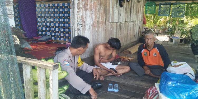 FOTO: HUMAS POLRESTA/MATAKALTENG - Bhabinkamtibmas Kelurahan Pahandut Seberang, Aiptu Tutut Ari Bowo, pada saat menenangkan sang anak yang mengamuk.