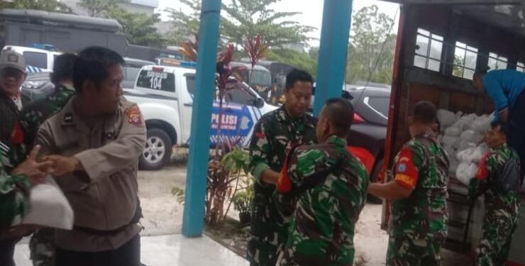 FOTO : IST/MATAKALTENG - Petugas dari TNI/Polri membantu menyalurkan bantuan pangan untuk para korban banjir di tujuh desa di Kabupaten Kapuas.