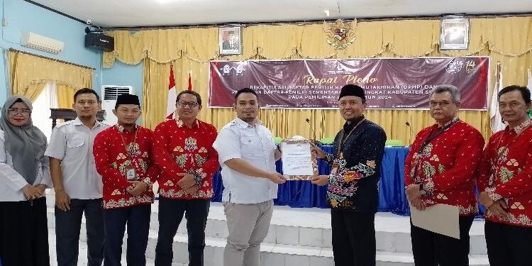 FOTO : AKH/MATAKALTENG - Ketua KPU Sukamara Ahmad Zen Allantany saat menyerahkan DPS Pemilu 2024 ke Ketua Bawaslu Sukamara, Irwansyah.