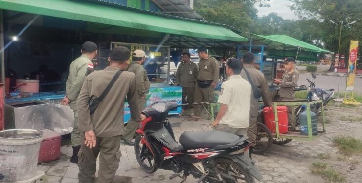 FOTO : IST/MATAKALTENG - Petugas Satpol PP Kabupaten Kotim saat melakukan sosialisasi dan menertibkan pedagang makanan yang berjualan secara terbuka di siang hari di Kota Sampit, Kamis 6 April 2023.